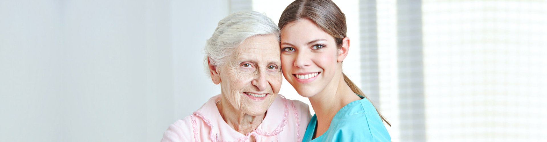 nurse and senior woman are smiling at home